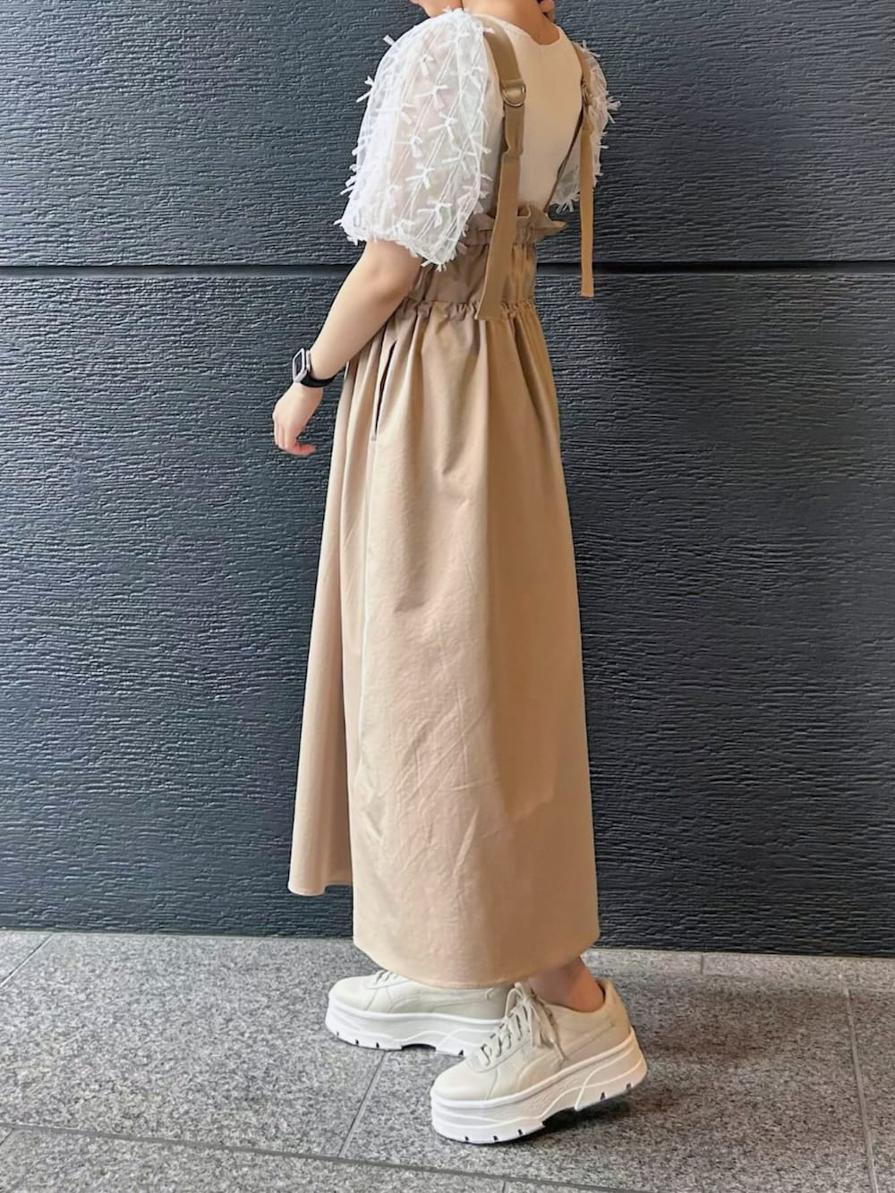 ベージュ系のジャンパースカート、ホワイト系のニット/セーターを着用したレディースの冬コーディネートの2枚目の写真