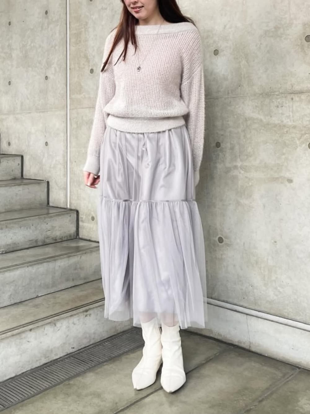 グレー系のスカート、グレー系のニット/セーターを着用したレディースの冬コーディネートの2枚目の写真