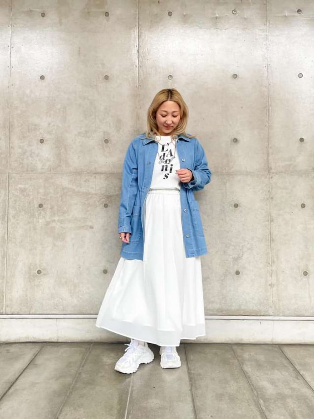 ブルー系のデニムジャケット、ホワイト系のスカート、ホワイト系のTシャツ/カットソーを着用したレディースの春コーディネートの2枚目の写真