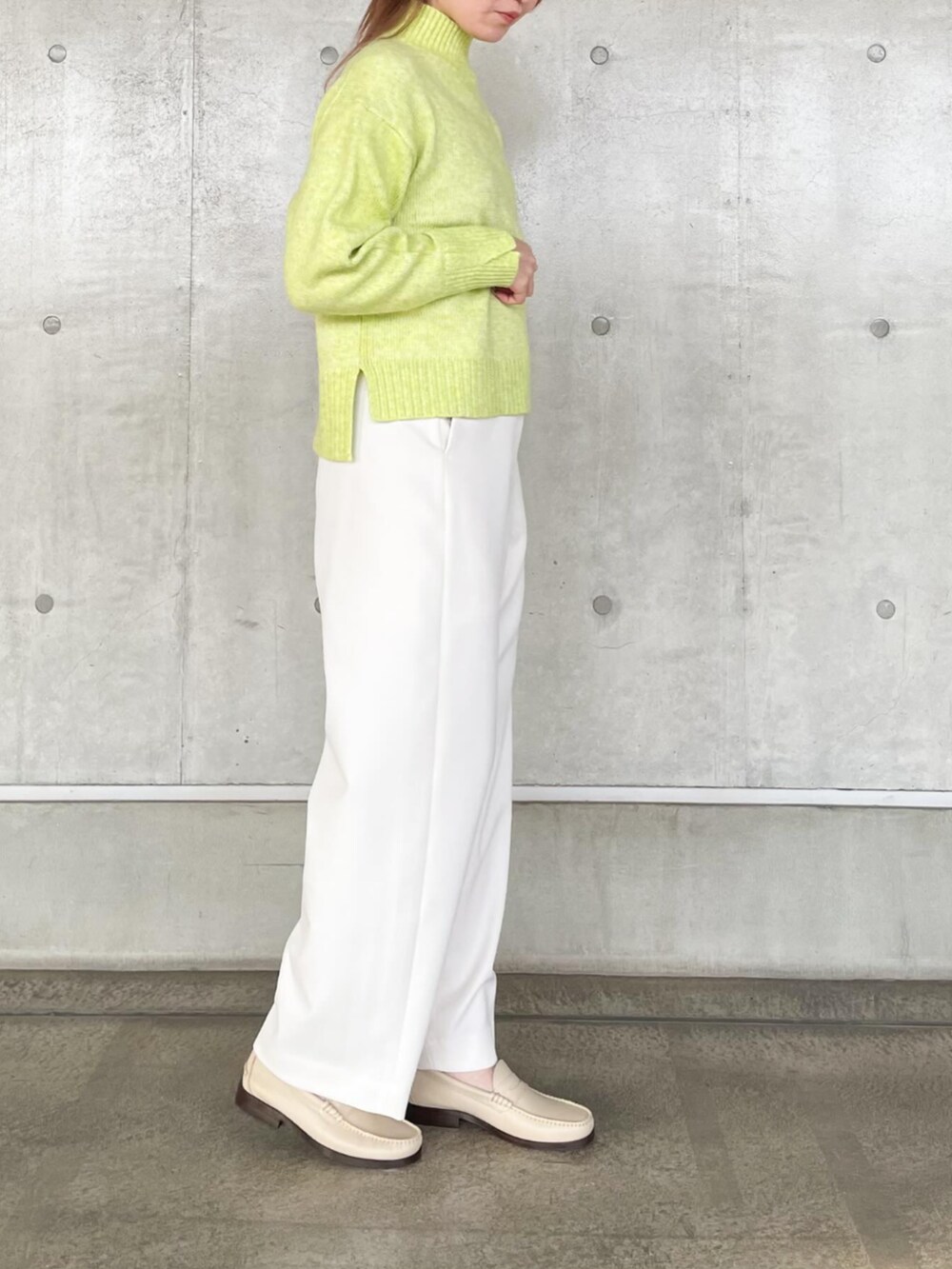 イエロー系のニット/セーター、ホワイト系のその他パンツを着用したレディースの秋コーディネートの3枚目の写真