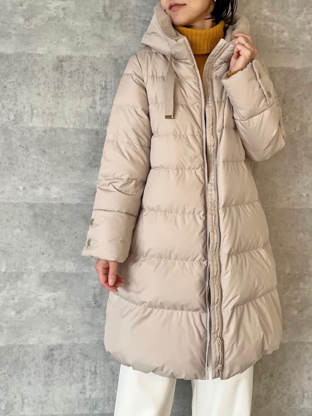 ベージュ系のダウンジャケット/コートを着用したレディースの冬コーディネートの2枚目の写真