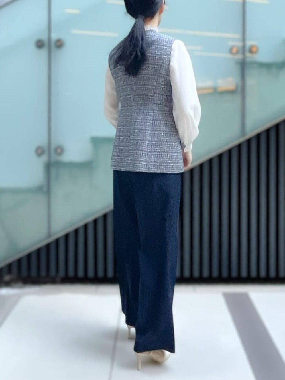 ホワイト系のシャツ/ブラウス、ブルー系のノーカラージャケット、グレー系のスラックスを着用したレディースの冬コーディネートの2枚目の写真