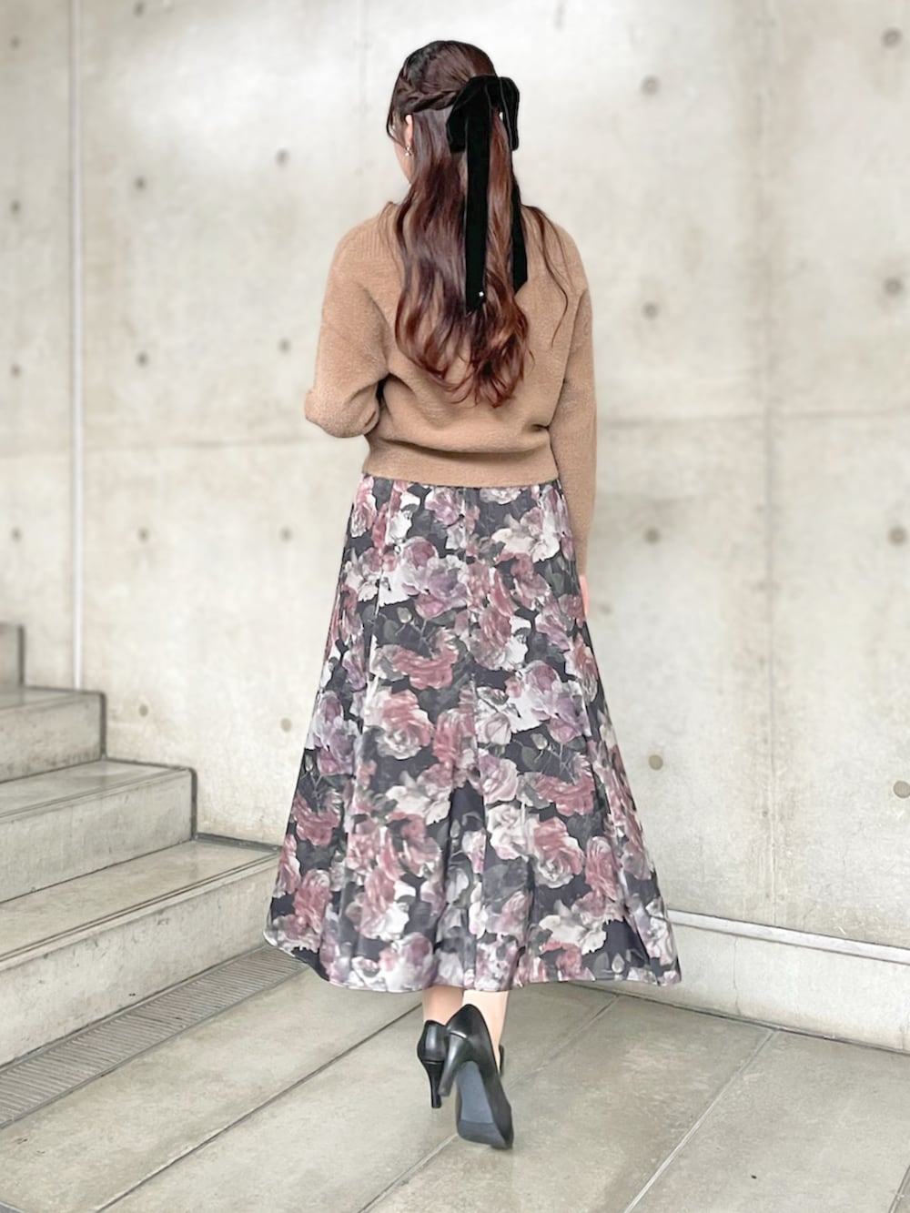 ブラック系のスカート、ブラウン系のニット/セーターを着用したレディースの秋コーディネートの2枚目の写真