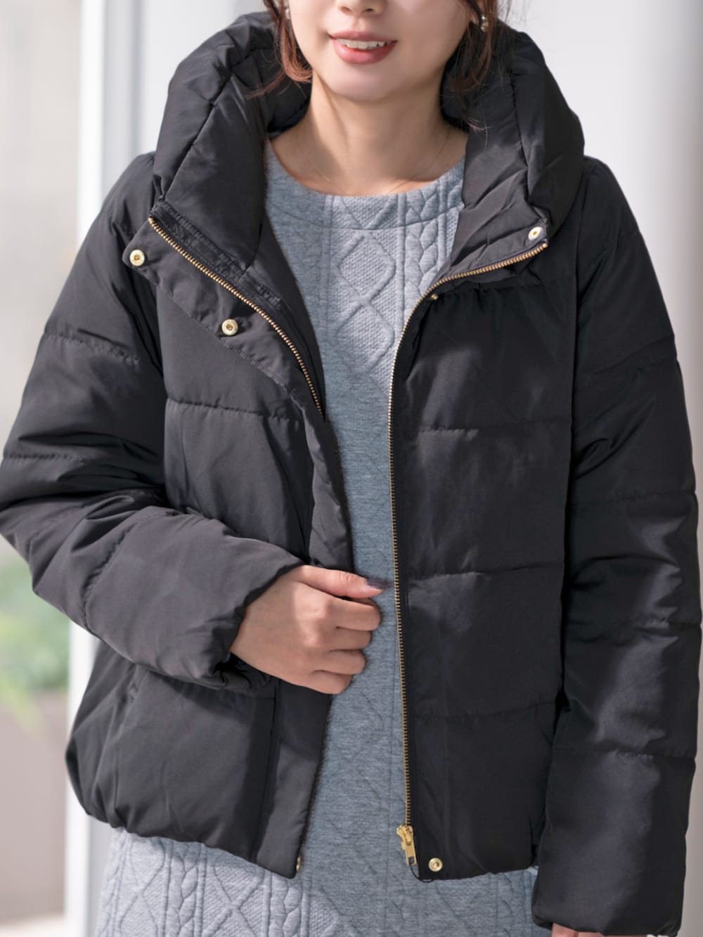 ブラック系のダウンジャケット/コート、グレー系のワンピースを着用したレディースの冬コーディネートの2枚目の写真