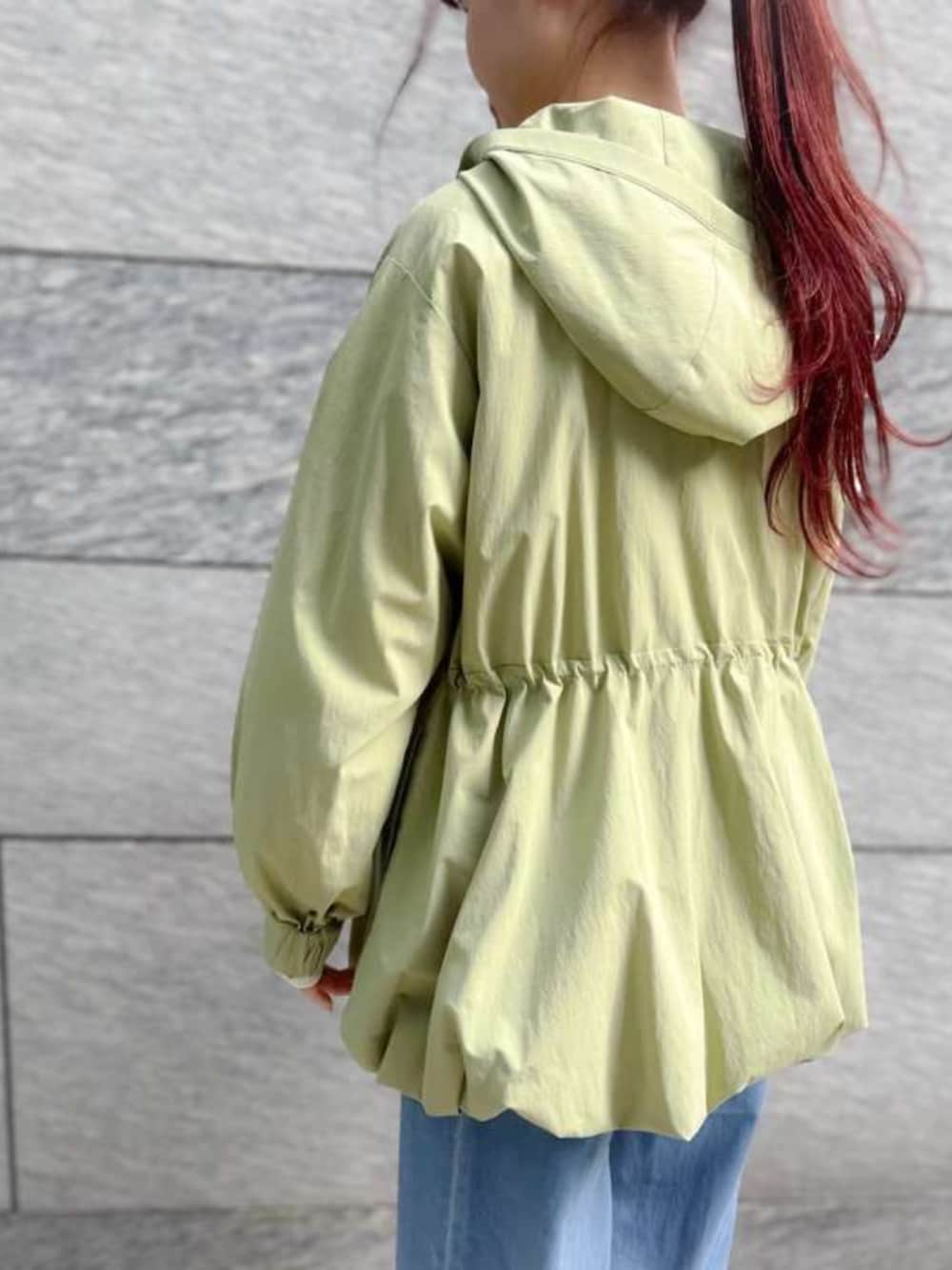 グリーン系のマウンテンパーカー、ブルー系のデニムパンツを着用したレディースの冬コーディネートの2枚目の写真