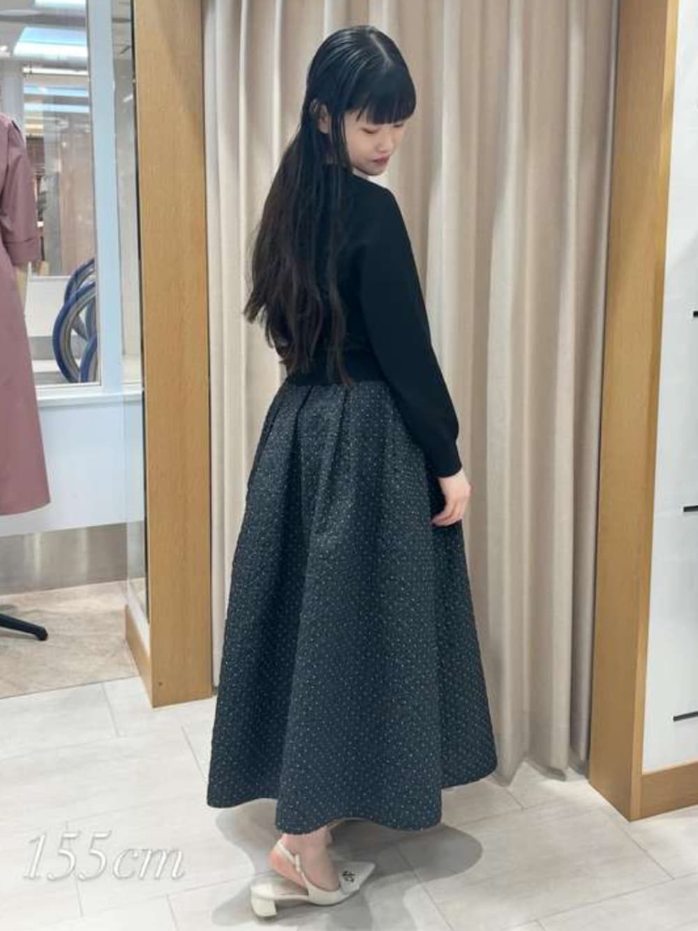 ブラック系のスカート、ブラック系のカーディガン/ボレロを着用したレディースの春コーディネートの2枚目の写真