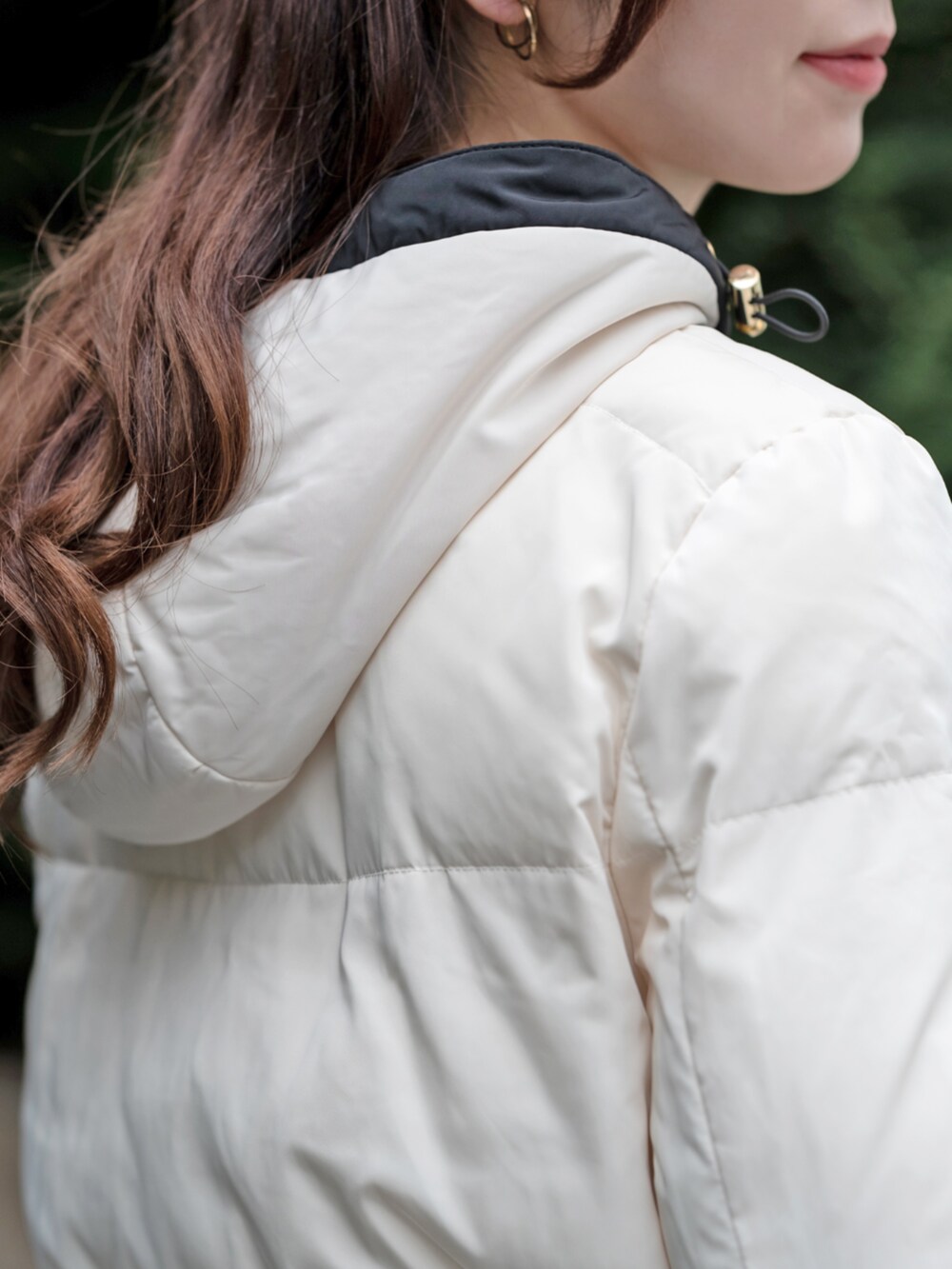 ホワイト系のブルゾン、ブラック系のスカートを着用したレディースの秋コーディネートの3枚目の写真