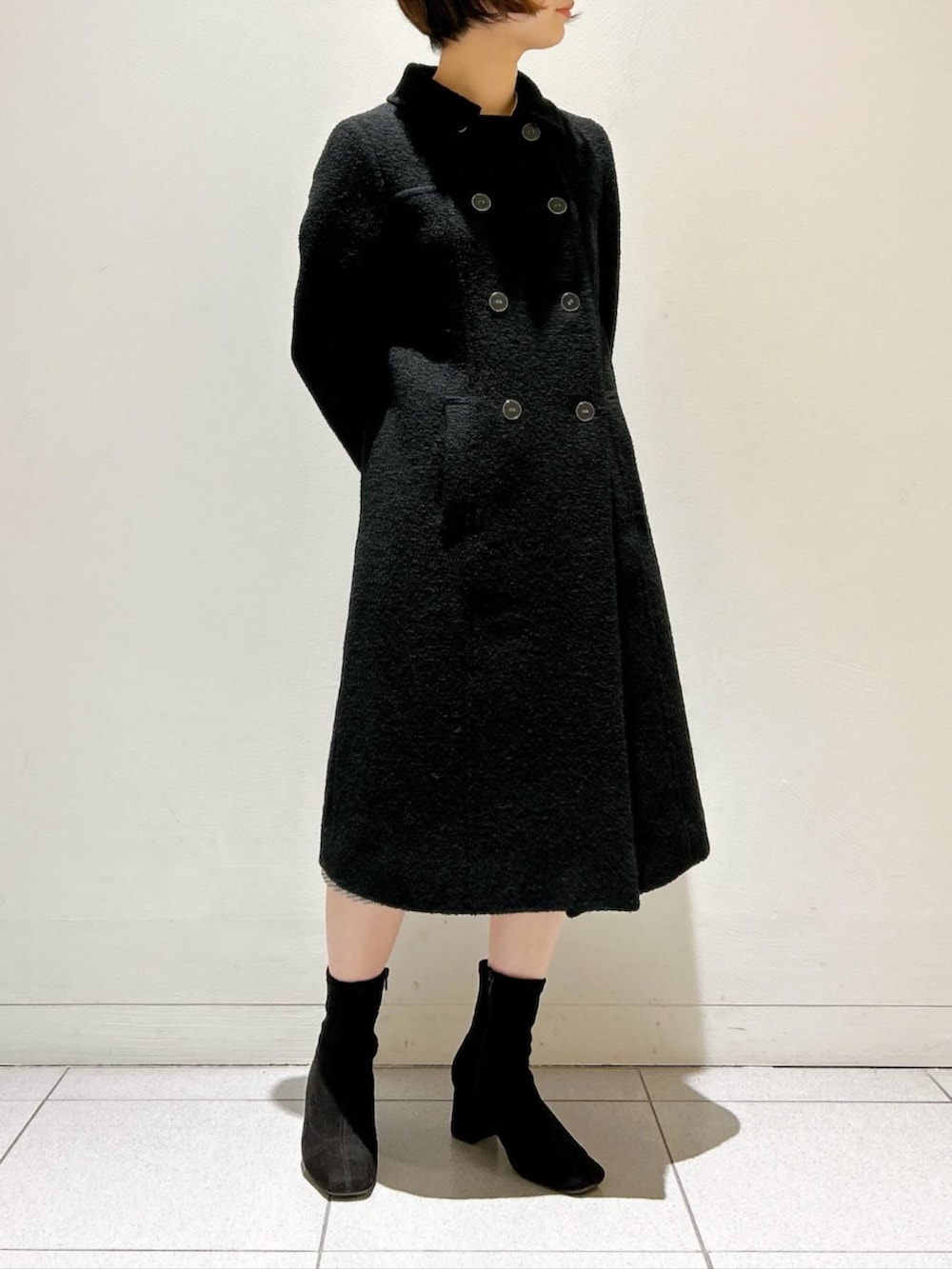 ブラック系のステンカラーコートを着用したレディースの秋コーディネートの2枚目の写真