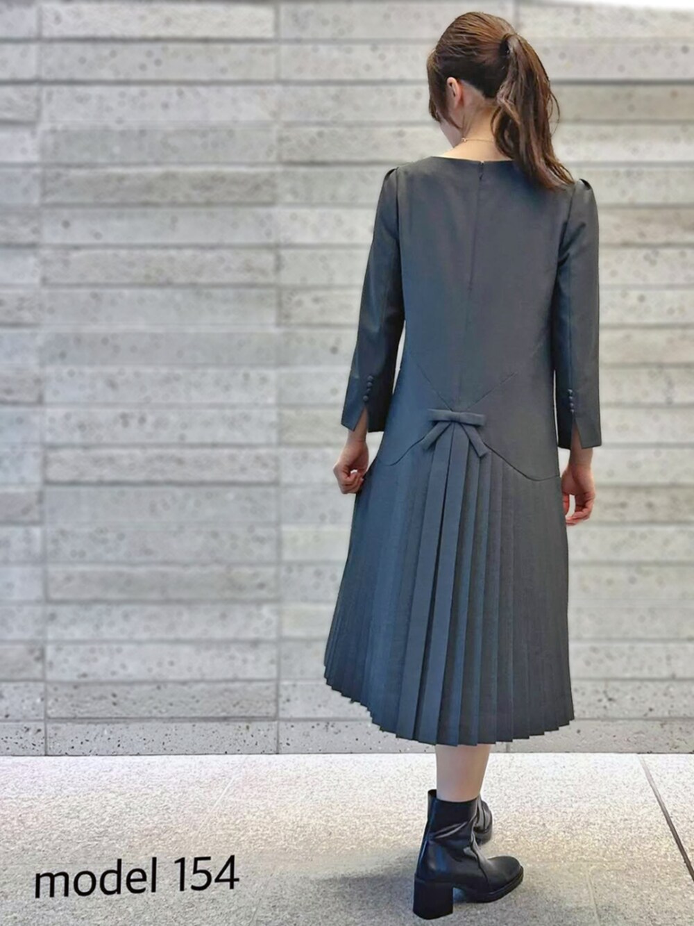 グレー系のワンピースを着用したレディースの秋コーディネートの2枚目の写真