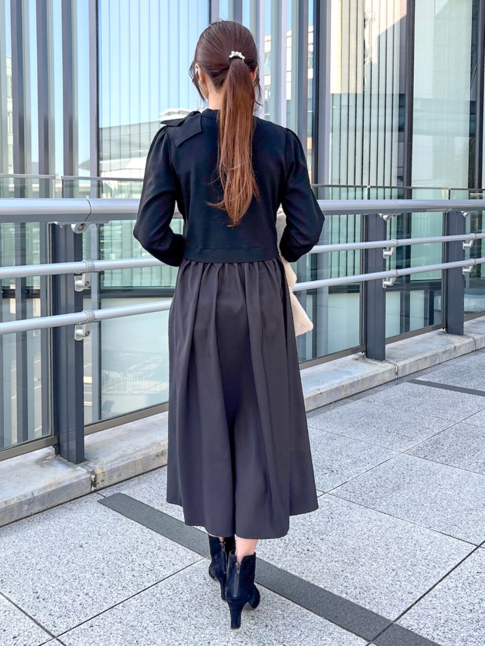 ブラック系のワンピースを着用したレディースの冬コーディネートの2枚目の写真