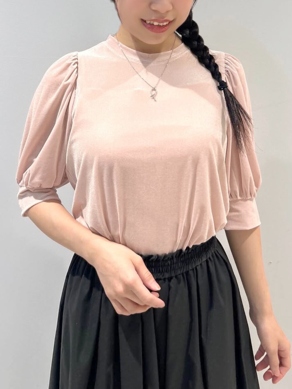 ブラック系のスカート、ピンク系のTシャツ/カットソーを着用したレディースの秋コーディネートの2枚目の写真