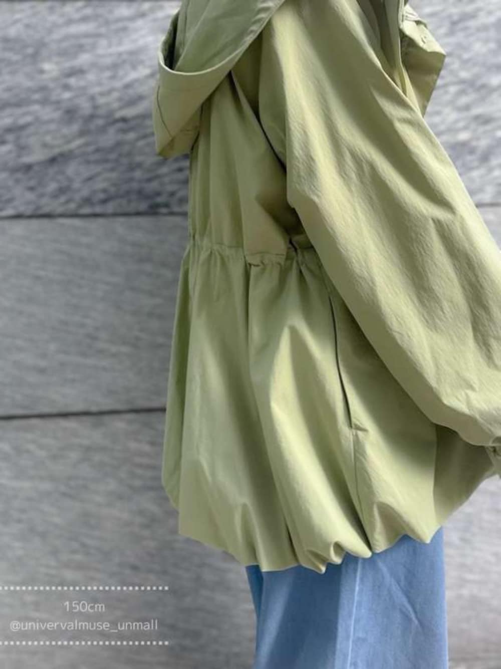 グリーン系のマウンテンパーカー、ブルー系のデニムパンツを着用したレディースの冬コーディネートの3枚目の写真