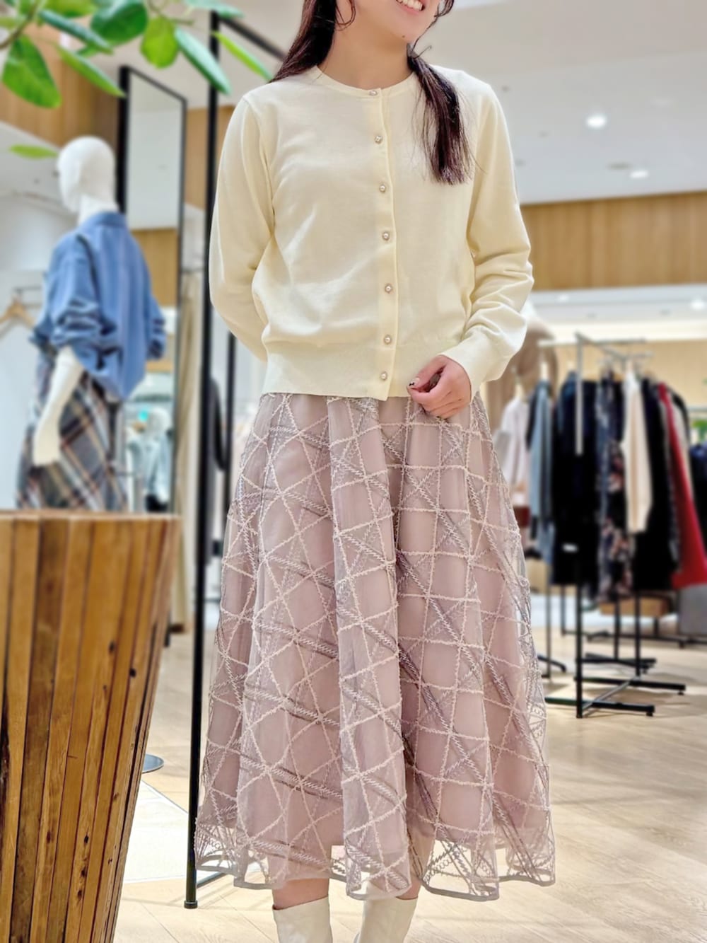 ホワイト系のカーディガン/ボレロ、ピンク系のスカートを着用したレディースの秋コーディネートの2枚目の写真