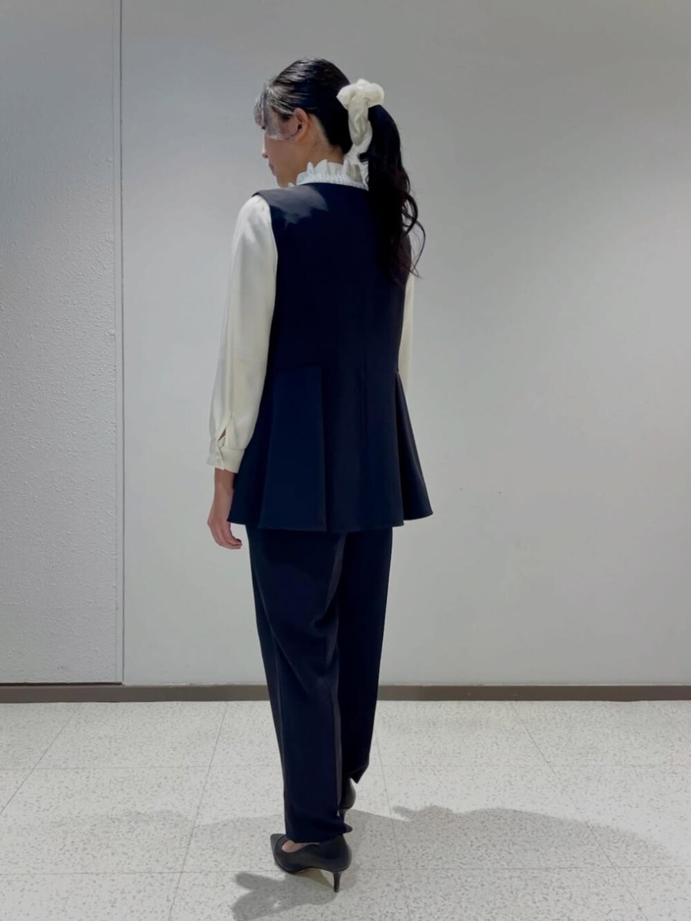 ホワイト系のシャツ/ブラウス、ブルー系のノーカラージャケット、ブルー系のスラックスを着用したレディースの冬コーディネートの2枚目の写真