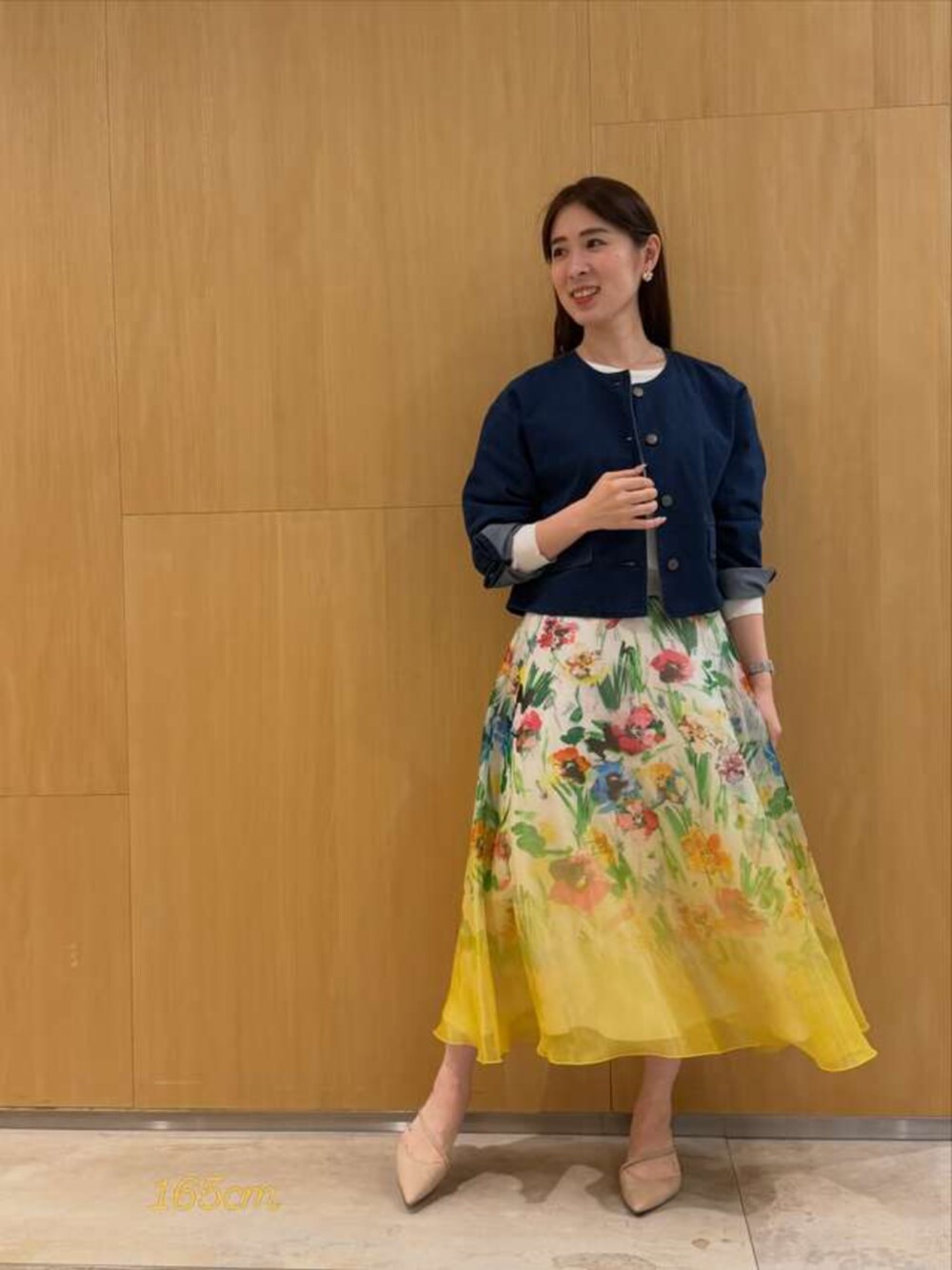 イエロー系のスカート、ブルー系のデニムジャケットを着用したレディースの春コーディネートの3枚目の写真