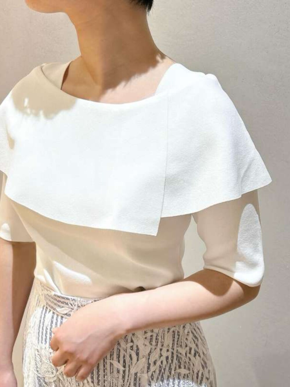 ブルー系のスカート、ホワイト系のニット/セーターを着用したレディースの春コーディネートの2枚目の写真