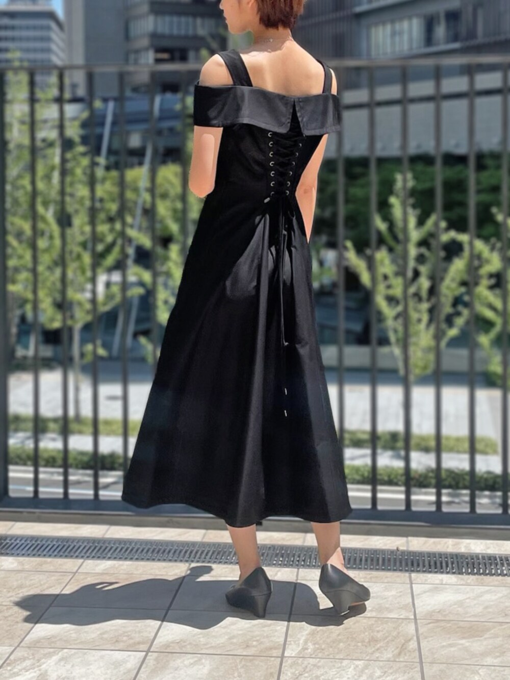 ブラック系のジャンパースカートを着用したレディースの夏コーディネートの2枚目の写真