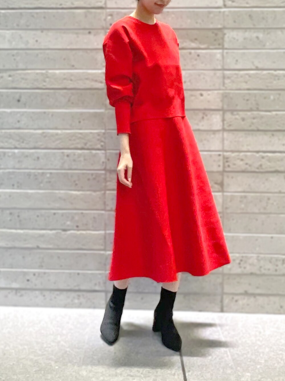 レッド系のニット/セーター、レッド系のスカートを着用したレディースの秋コーディネートの2枚目の写真