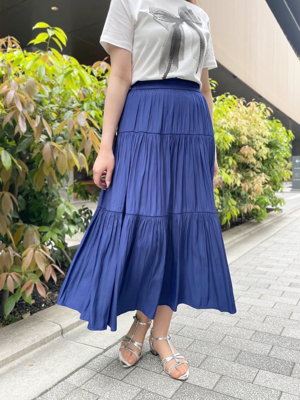 「大人カジュアル、きれいめカジュアル、ティアードスカート、ブルーコーデ、夏コーデ、STRAWBERRY-FIELDS、ストロベリーフィールズ、パウダーサテン、京都ポルタ店_HARUKA、リボンプリントTシャツ」｜「STRAWBERRY-FIELDSのパウダーサテンティアードスカート（スカート、ブルー系）」を使った、STRAWBERRY-FIELDSさん（レディース・168cm）の春コーディネートの2枚目の写真