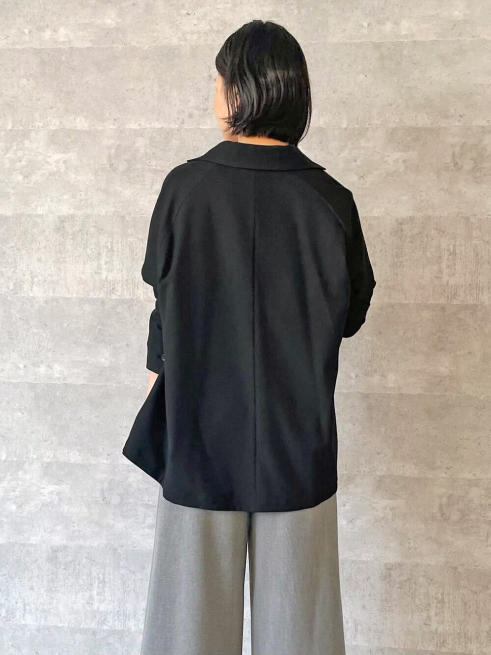 ブラック系のテーラードジャケット、グレー系のスラックスを着用したレディースの秋コーディネートの3枚目の写真