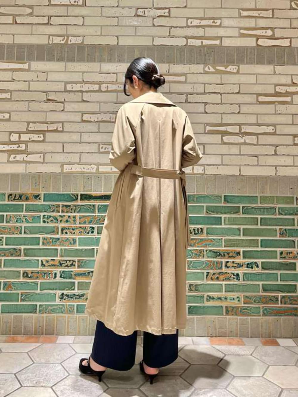 ベージュ系のトレンチコート、ホワイト系のシャツ/ブラウス、ブルー系のその他パンツを着用したレディースの冬コーディネートの3枚目の写真