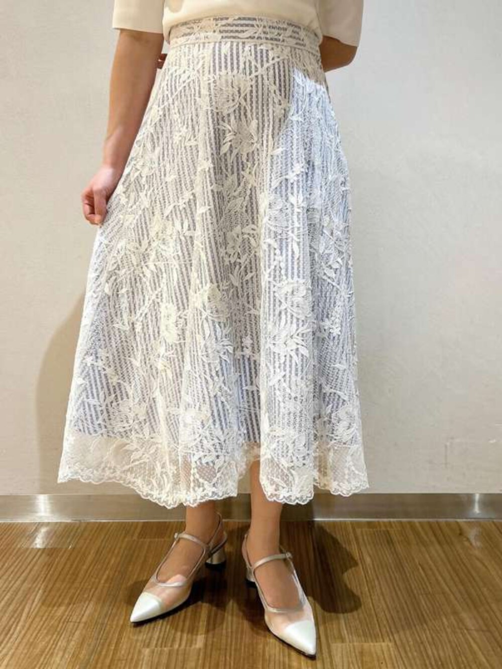 ブルー系のスカート、ホワイト系のニット/セーターを着用したレディースの春コーディネートの3枚目の写真