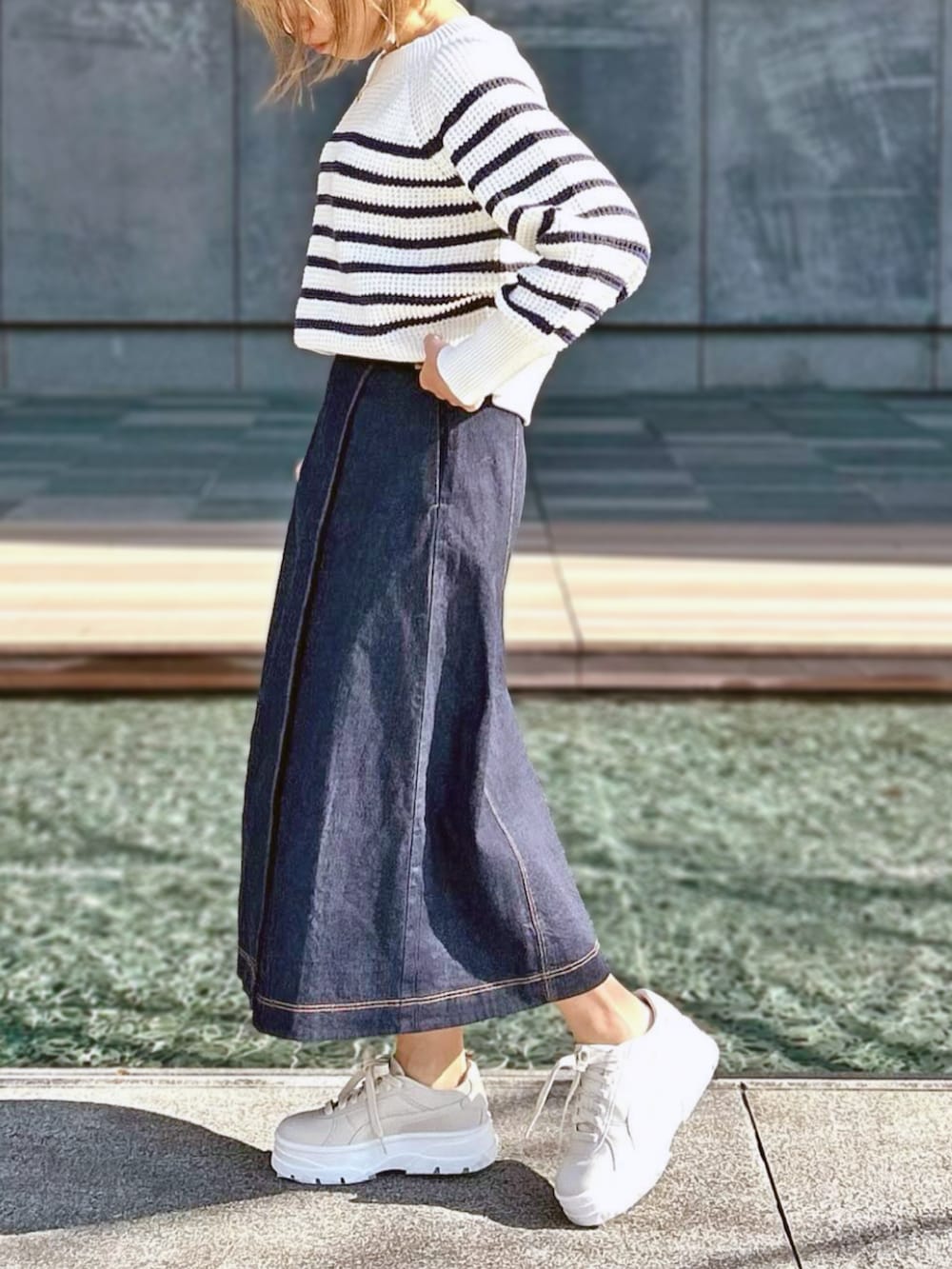 ブルー系のスカート、ホワイト系のニット/セーターを着用したレディースの冬コーディネートの2枚目の写真