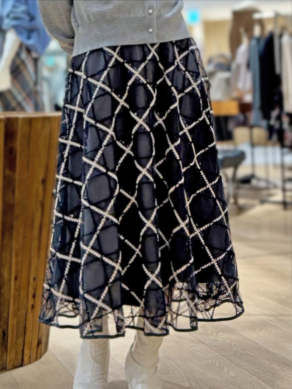 グレー系のカーディガン/ボレロ、グレー系のスカートを着用したレディースの秋コーディネートの2枚目の写真