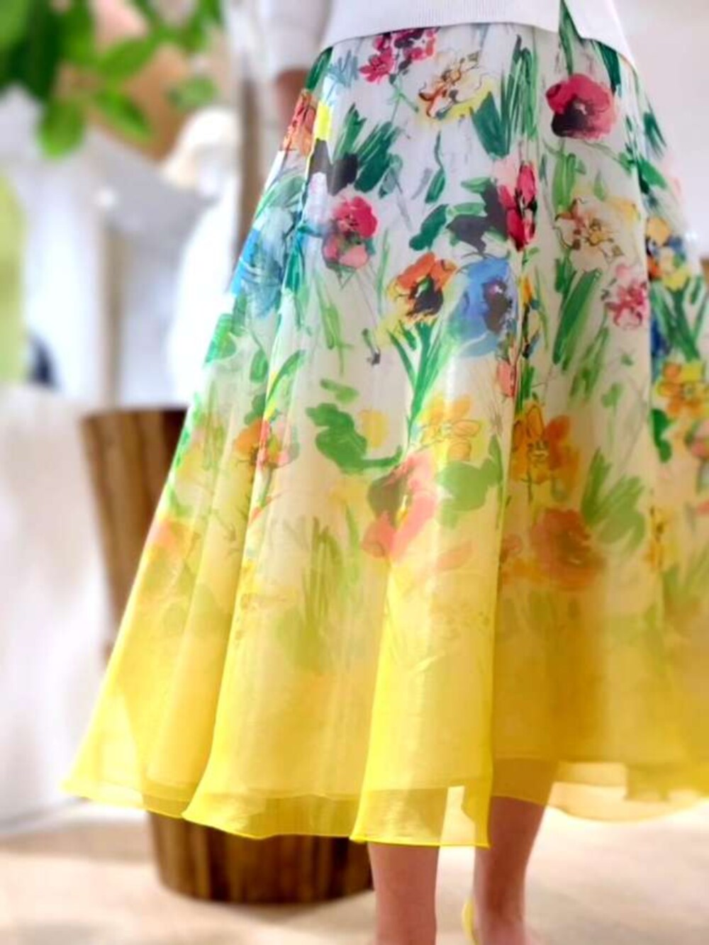 イエロー系のスカート、ホワイト系のニット/セーターを着用したレディースの春コーディネートの2枚目の写真