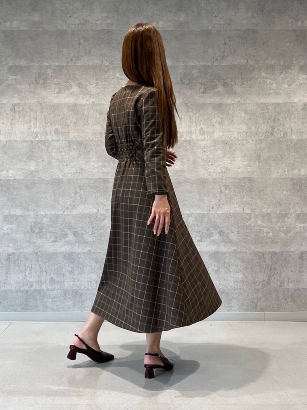 ブラウン系のワンピースを着用したレディースの秋コーディネートの2枚目の写真