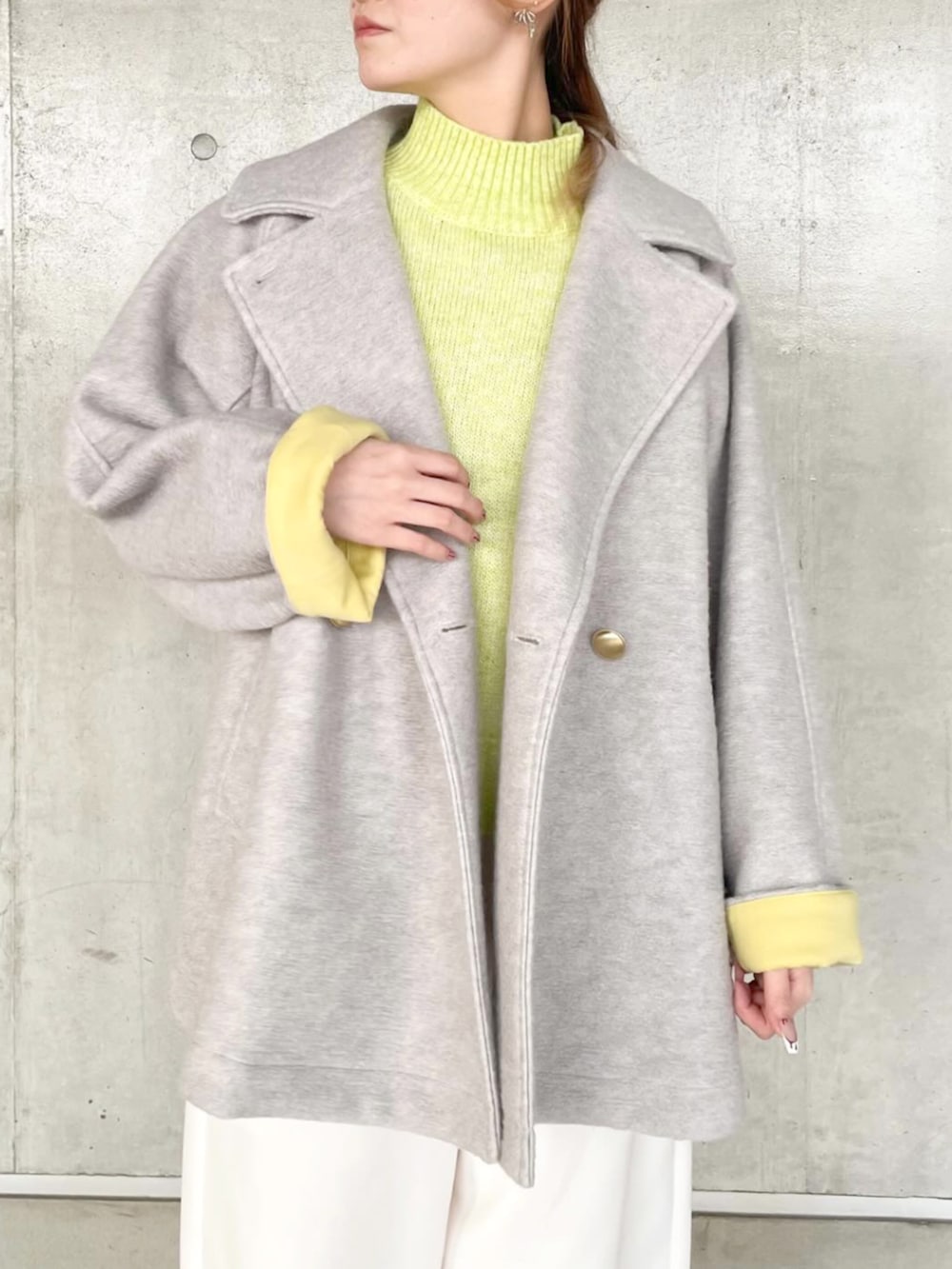 グレー系のその他アウター、イエロー系のニット/セーター、ホワイト系のその他パンツを着用したレディースの秋コーディネートの2枚目の写真