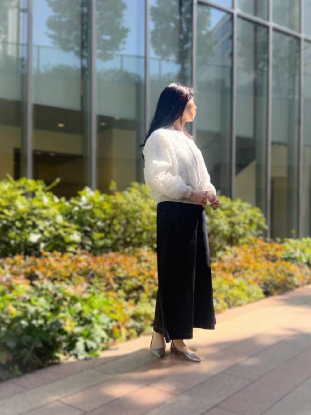 ホワイト系のブルゾン、ブルー系のデニムスカートを着用したレディースの春コーディネートの3枚目の写真