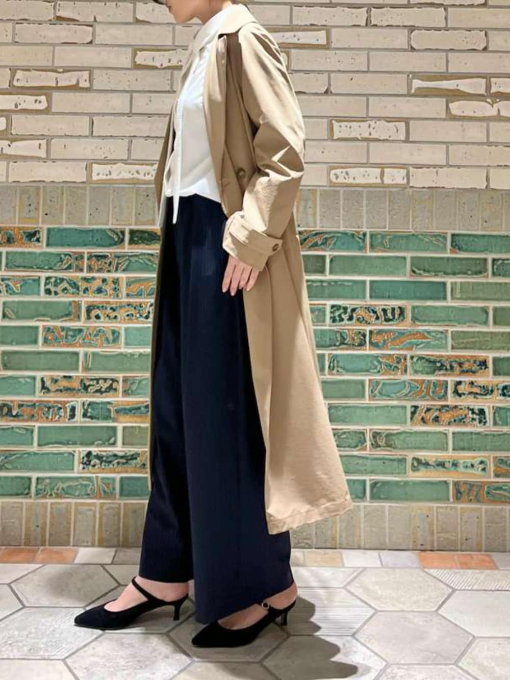 ベージュ系のトレンチコート、ホワイト系のシャツ/ブラウス、ブルー系のその他パンツを着用したレディースの冬コーディネートの2枚目の写真