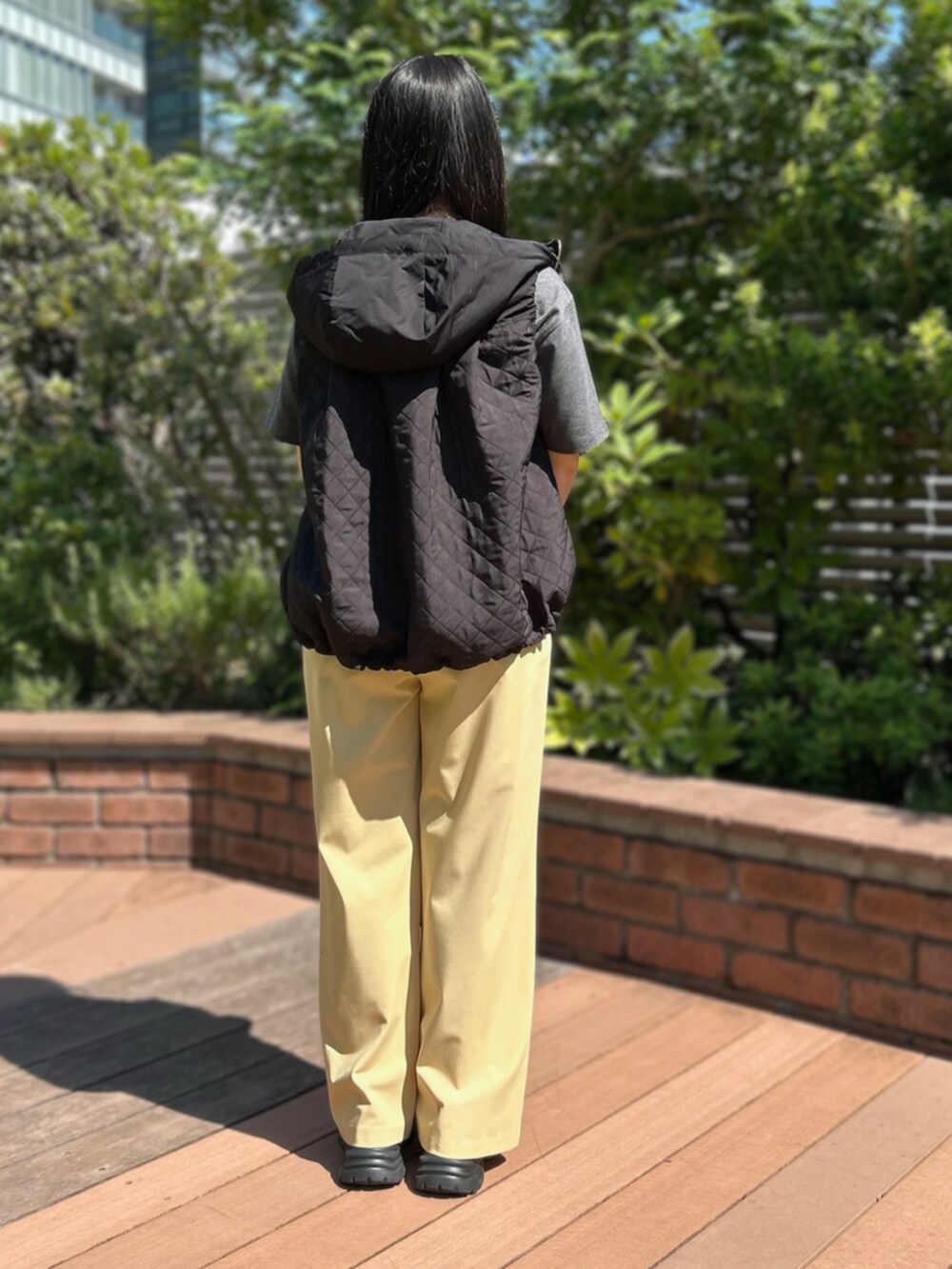 グレー系のTシャツ/カットソー、イエロー系のスラックスを着用したレディースの秋コーディネートの2枚目の写真