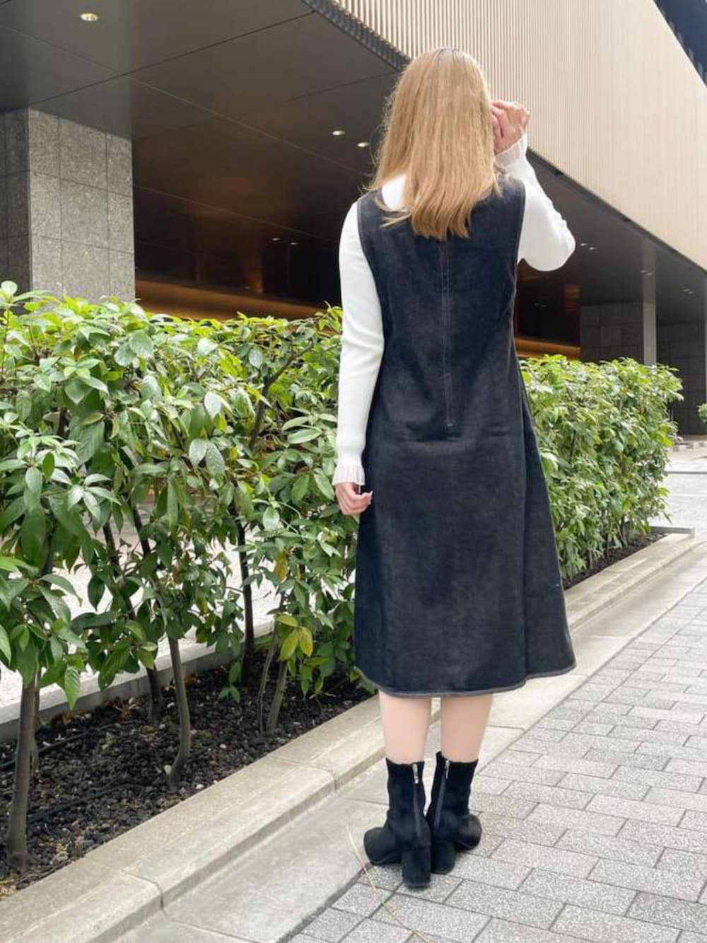 ホワイト系のニット/セーター、ブルー系のジャンパースカートを着用したレディースの冬コーディネートの3枚目の写真