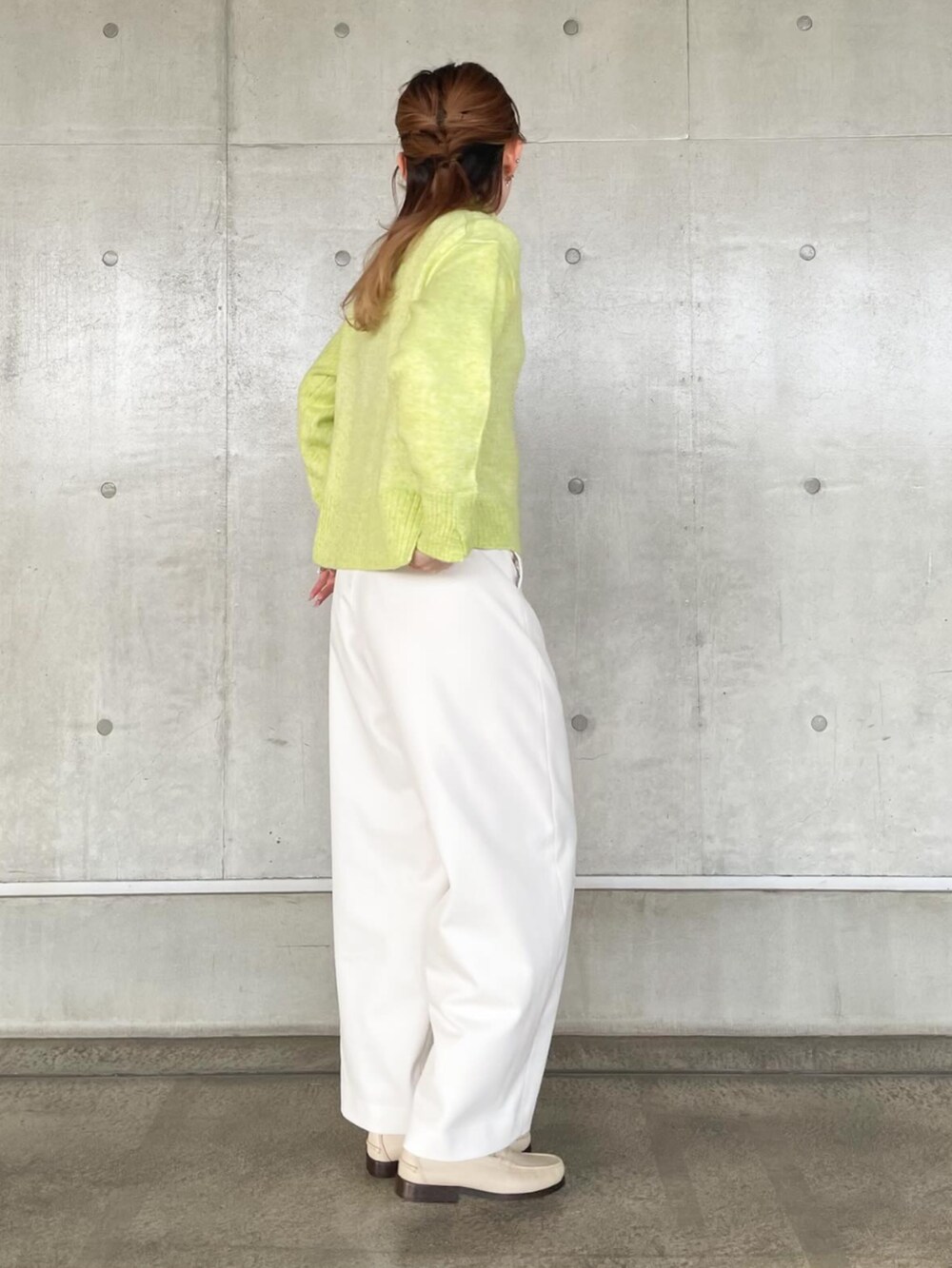 イエロー系のニット/セーター、ホワイト系のその他パンツを着用したレディースの秋コーディネートの4枚目の写真