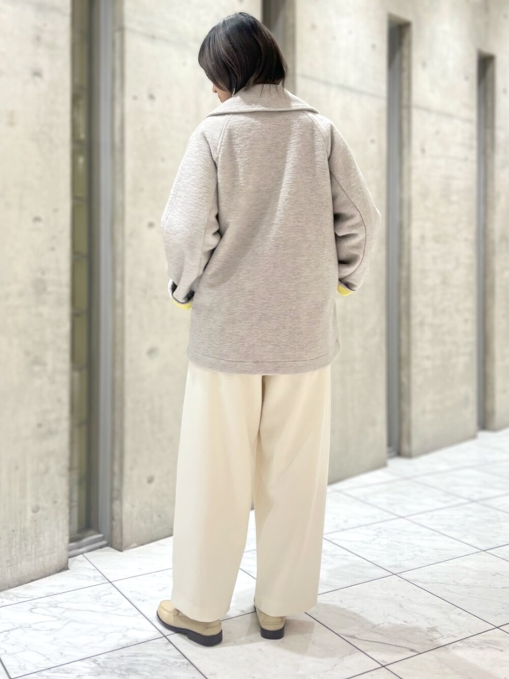 グレー系のその他アウター、イエロー系のニット/セーター、ホワイト系のその他パンツを着用したレディースの秋コーディネートの4枚目の写真