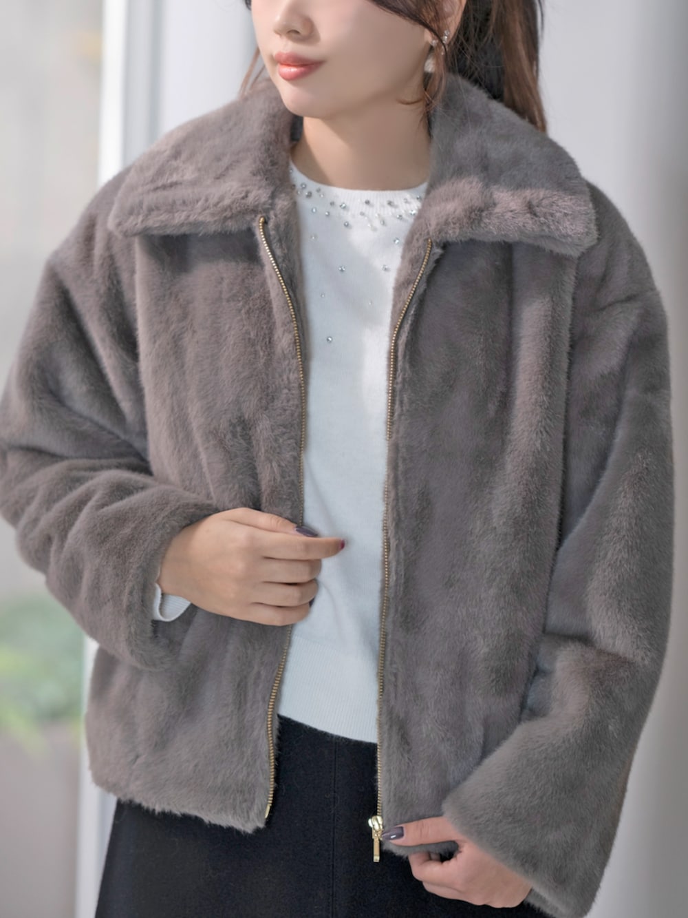 ホワイト系のニット/セーター、グレー系のその他アウターを着用したレディースの冬コーディネートの3枚目の写真