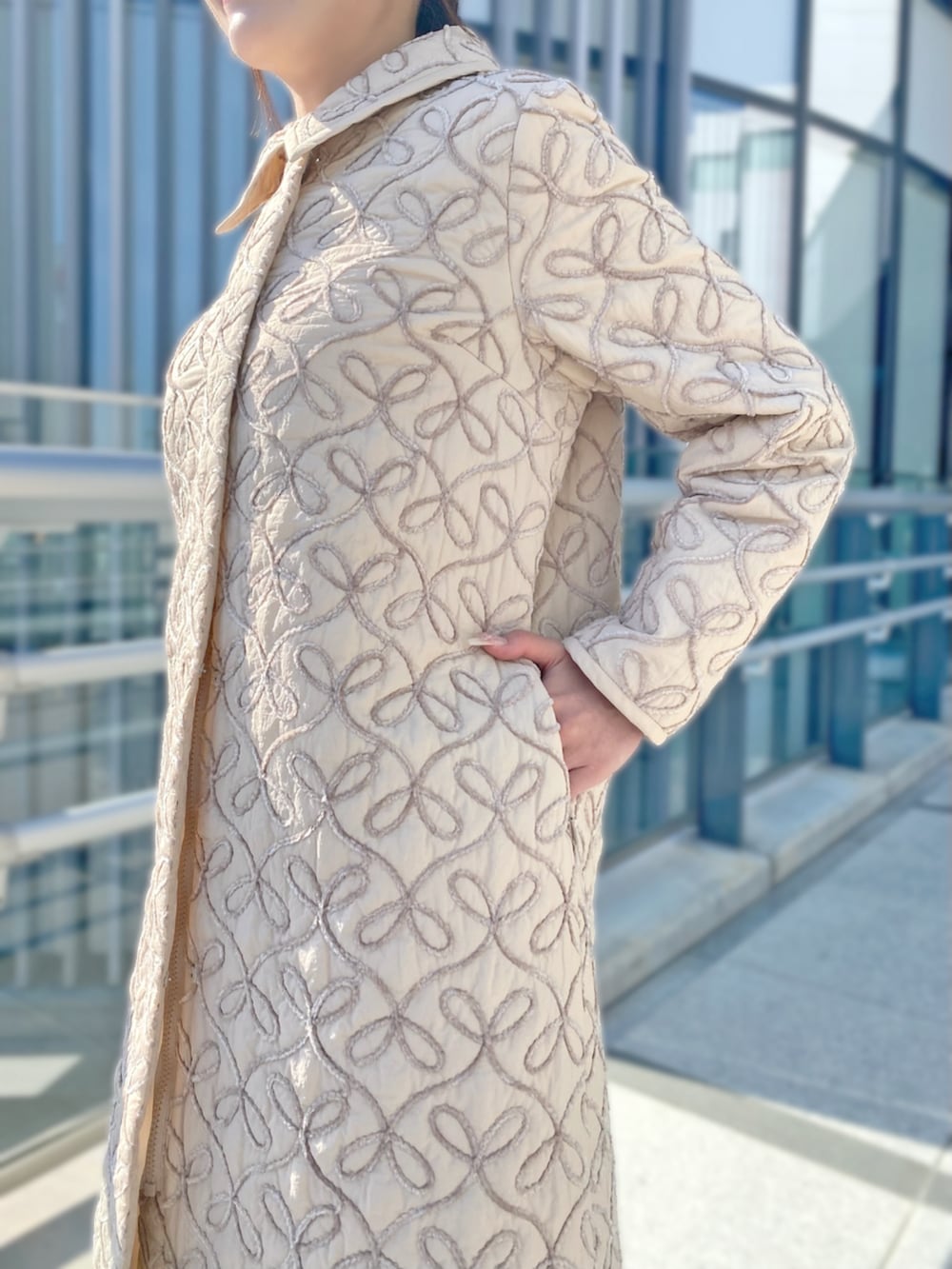 ホワイト系のスカート、ピンク系のステンカラーコート、ホワイト系のニット/セーターを着用したレディースの秋コーディネートの2枚目の写真