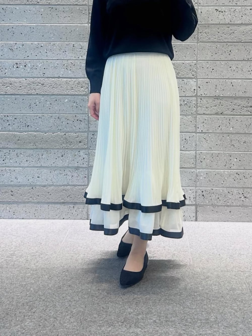 ホワイト系のスカート、ブラック系のニット/セーターを着用したレディースの冬コーディネートの3枚目の写真