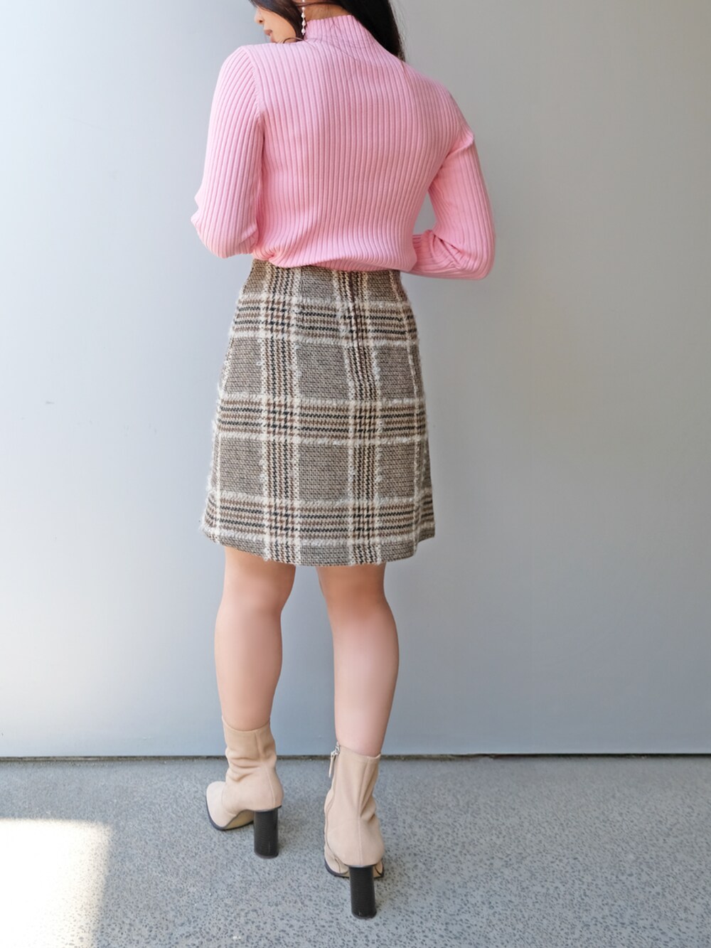 ブラウン系のスカート、ピンク系のニット/セーターを着用したレディースの秋コーディネートの3枚目の写真