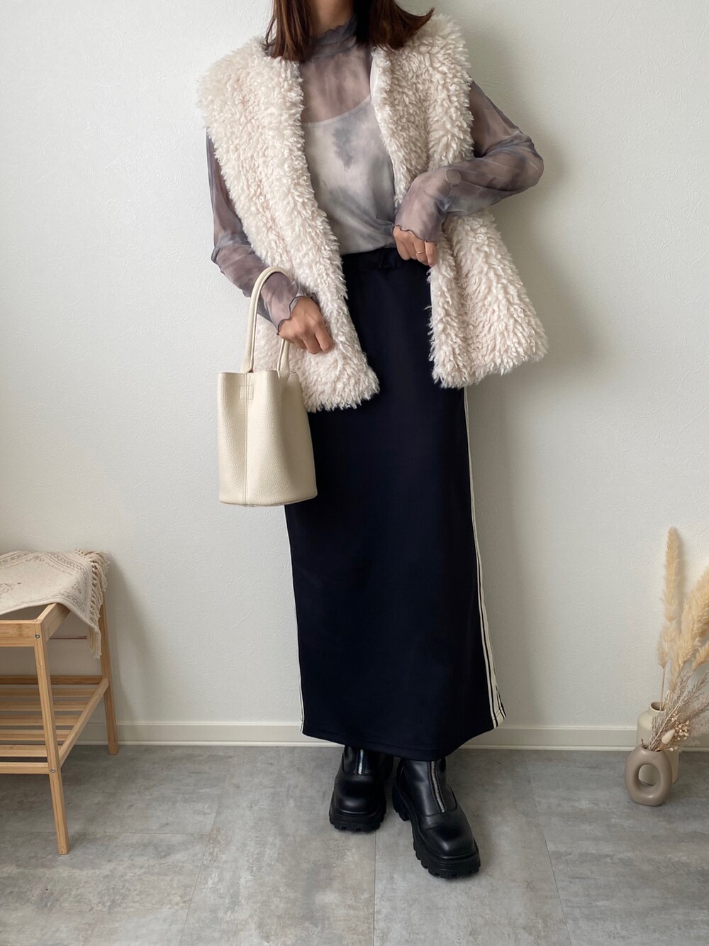 グレー系のトップス、ブラック系のブーツを着用したレディースの秋コーディネートの2枚目の写真