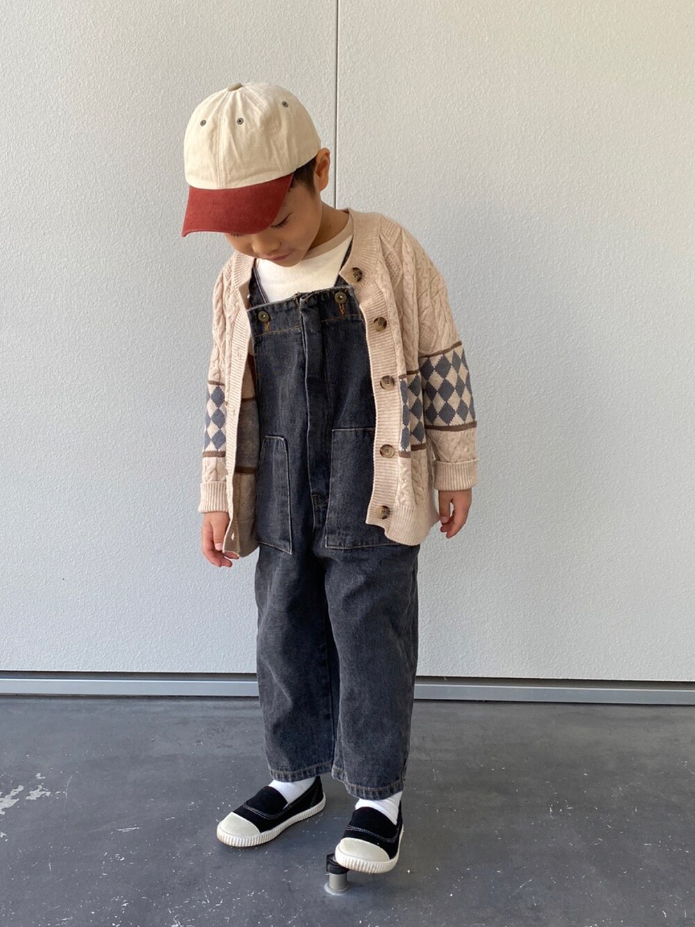 ブラック系のスリッポン、ブラック系のサロペット/オーバーオール、ベージュ系のTシャツ/カットソーを着用したキッズの春コーディネートの2枚目の写真