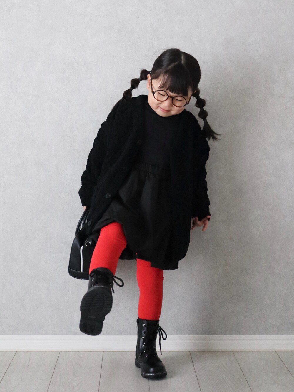 ブラック系のカーディガン/ボレロ、ブラック系のTシャツ/カットソー、レッド系のタイツ/ストッキングを着用したキッズの秋コーディネートの3枚目の写真