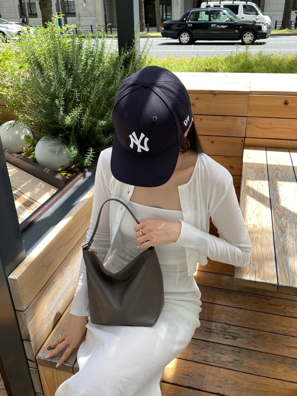 ホワイト系のスカート、ホワイト系のカーディガン/ボレロ、ブラウン系のショルダーバッグを着用したレディースの春コーディネートの2枚目の写真