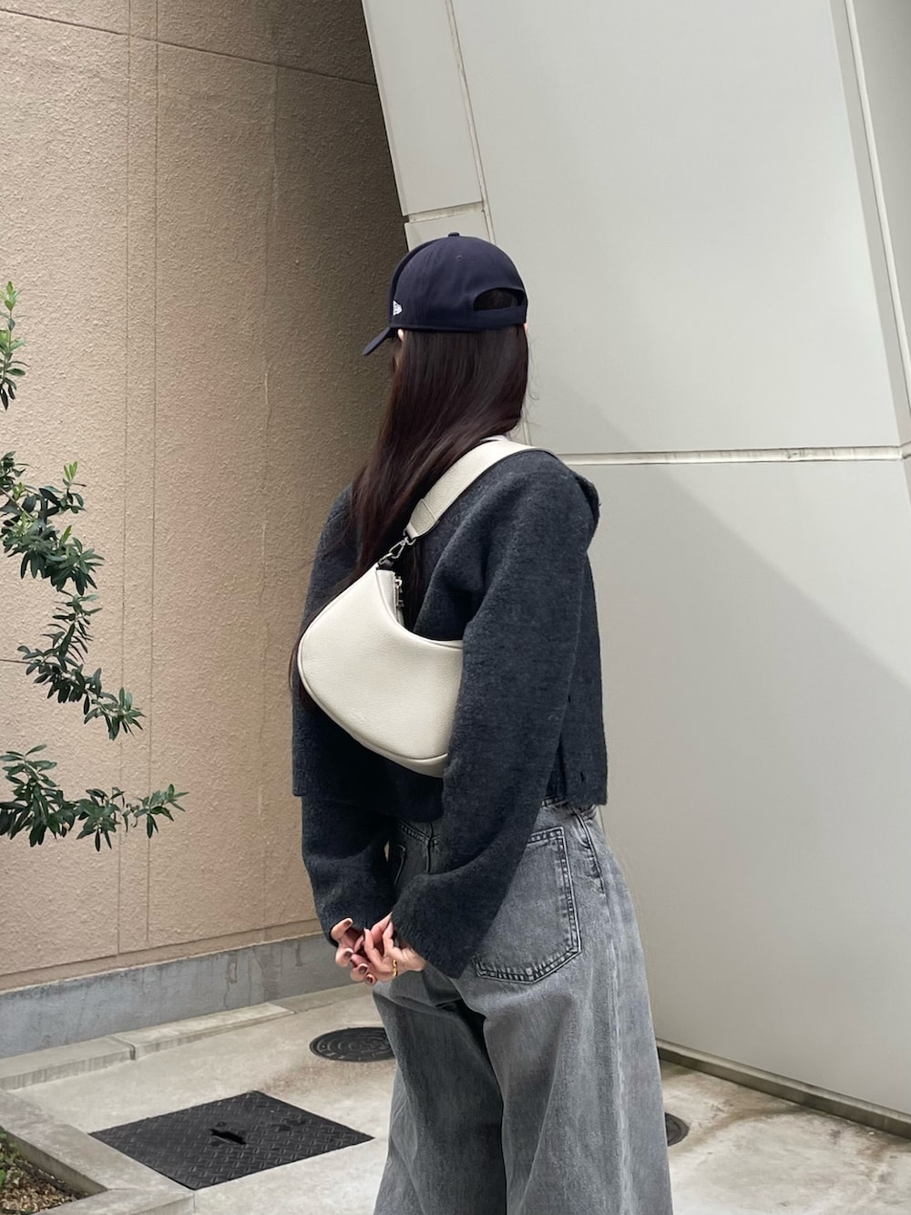 グレー系のショルダーバッグ、ホワイト系のタンクトップ、グレー系のカーディガン/ボレロを着用したレディースの冬コーディネートの3枚目の写真