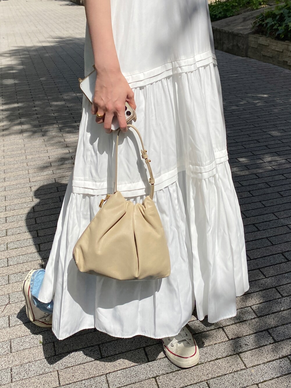 ホワイト系のワンピース、ベージュ系のショルダーバッグを着用したレディースの夏コーディネートの3枚目の写真