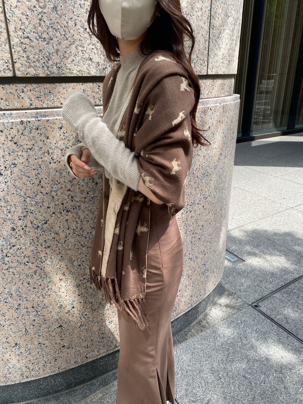 ベージュ系のニット/セーター、ブラウン系のストール/ショールを着用したレディースの夏コーディネートの2枚目の写真