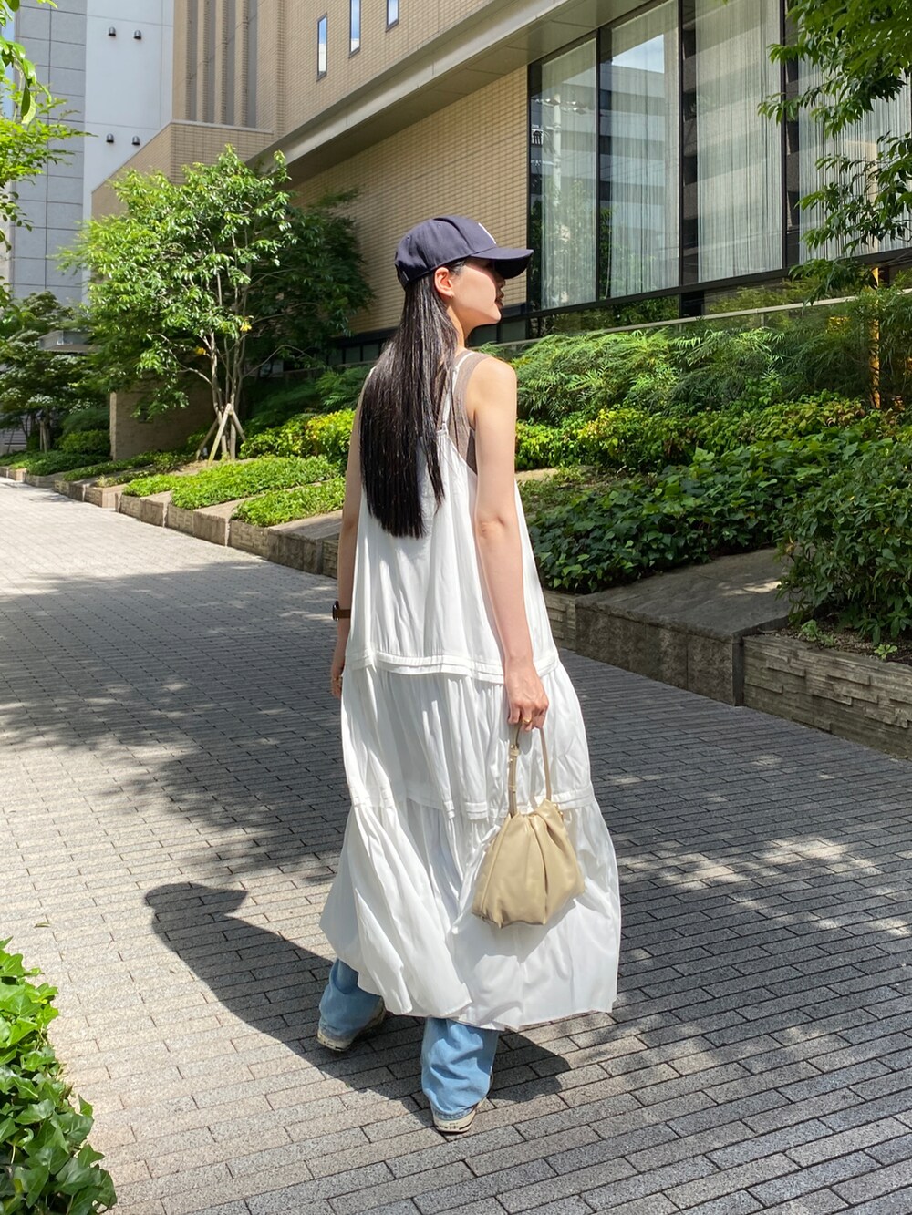 ホワイト系のワンピース、ベージュ系のショルダーバッグを着用したレディースの夏コーディネートの2枚目の写真