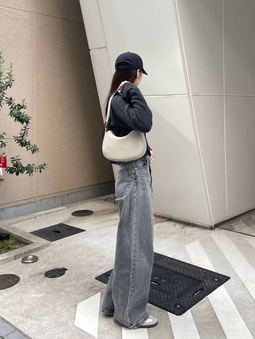 グレー系のショルダーバッグ、ホワイト系のタンクトップ、グレー系のカーディガン/ボレロを着用したレディースの冬コーディネートの2枚目の写真